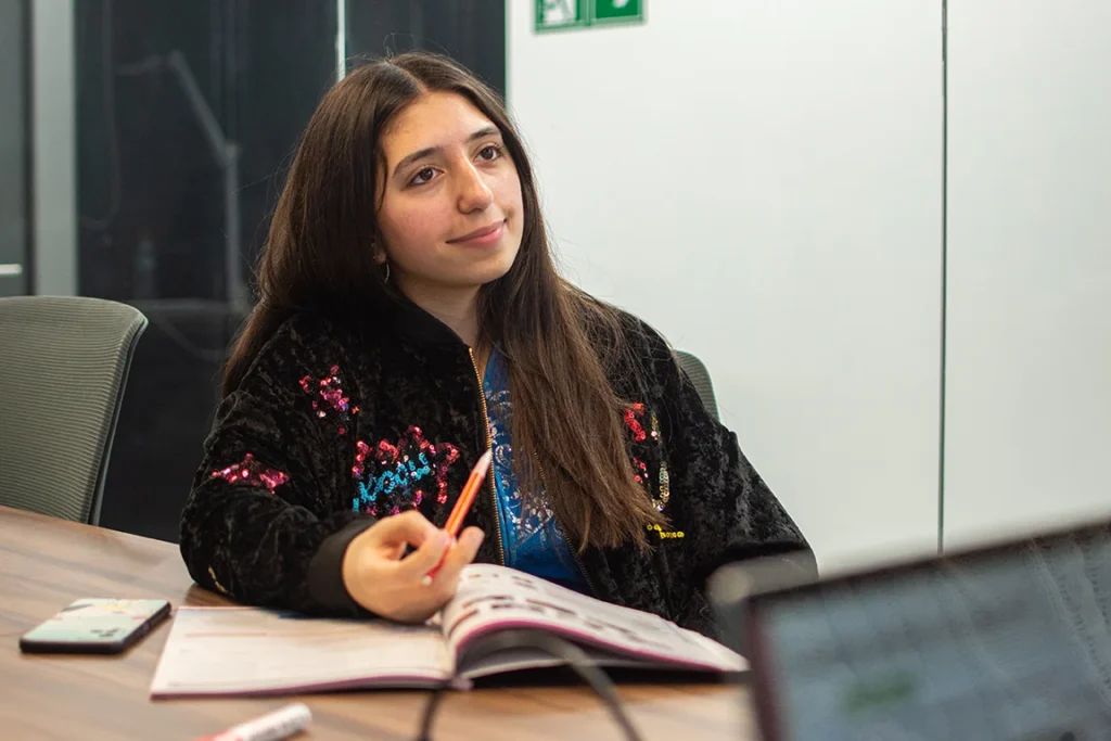 Alumnos concentrados estudiando material de preparación para el IELTS.