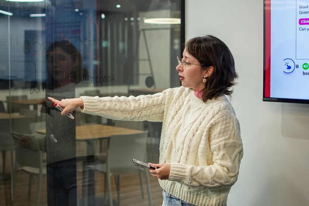Dos estudiantes practicando Speaking bajo la supervisión de un profesor.